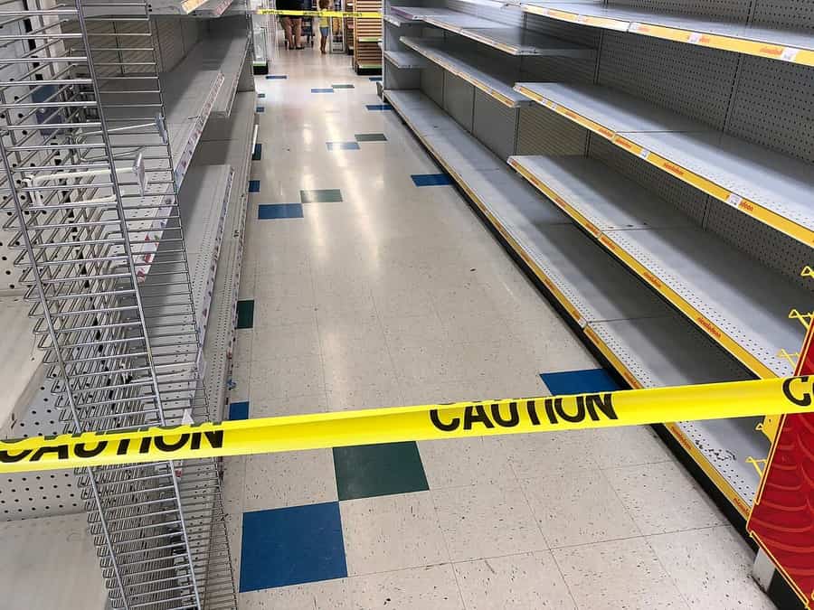 Empty store shelves behind yellow caution tape in a closing Toys R Us