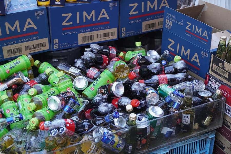 Blue Zima cartons stacked behind a tub of bottled drinks on ice